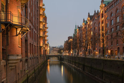 Bridge over canal amidst buildings in city