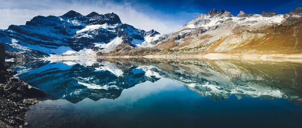Panoramic view of snowcapped mountains reflection in lake