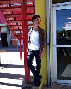 Young man standing against wall