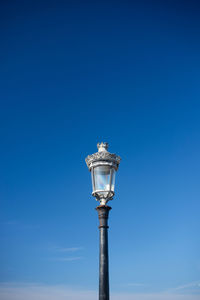 Low angle view of lighthouse against clear blue sky