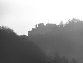 Low angle view of silhouette buildings against clear sky