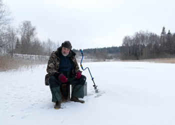 Landscape with ice fishing on a frozen lake, winter sport, outdoor recreation	