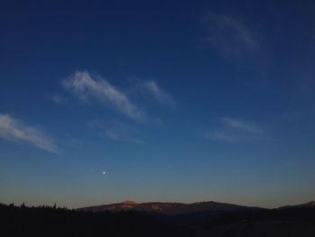 Scenic view of mountains against blue sky