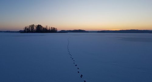 Scenic view of snow field against sky during sunset