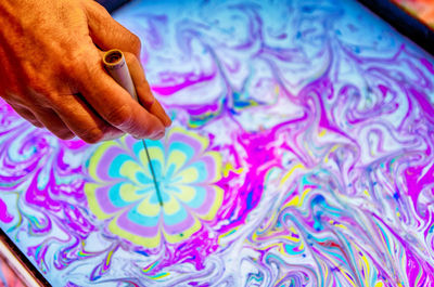 High angle view of person holding multi colored fabric