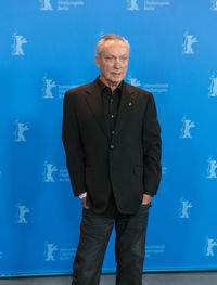 Mid adult man standing against blue background