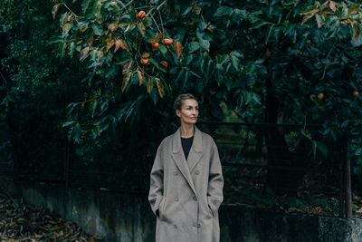 Portrait of young man standing against plants
