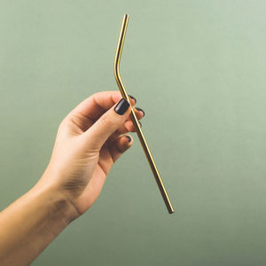 Close-up of hand holding straw against white background