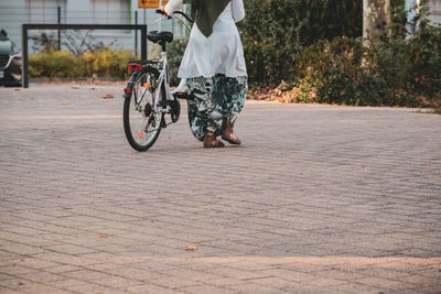 Rear view of man riding bicycle on road