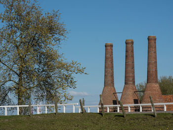 Built structure on field against clear blue sky