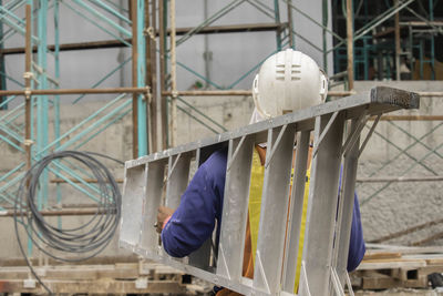 Rear view of worker working at construction site