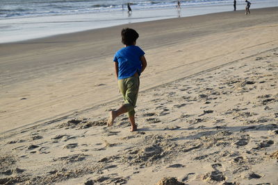 Rear view of man walking on beach