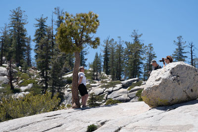 Rear view of people on rock against sky