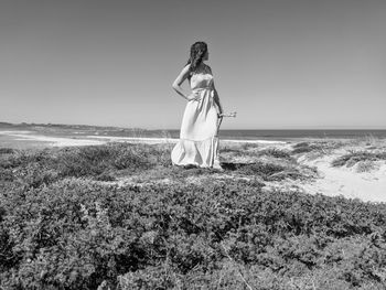 Woman standing on beach against sky