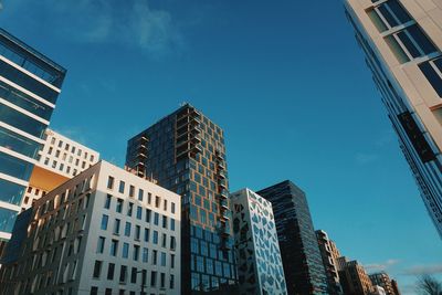 Low angle view of buildings in oslo against blue sky
