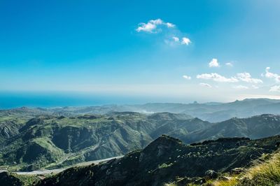 Scenic view of mountains against blue sky