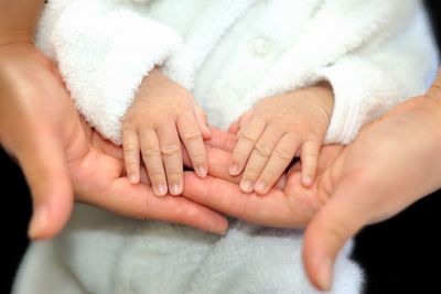 Cropped hands touching baby