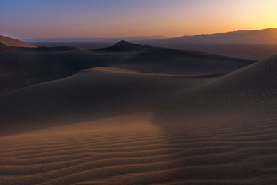 Scenic view of desert against sky during sunset