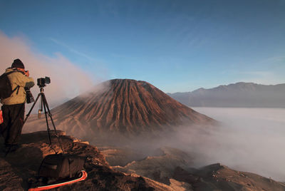Rear view of man photographing at mt bromo