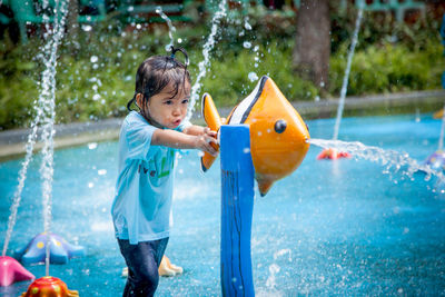 Playful girl playing in fountain