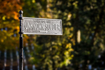 Close-up of road sign against trees