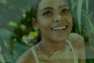 Close-up of smiling young woman against glass