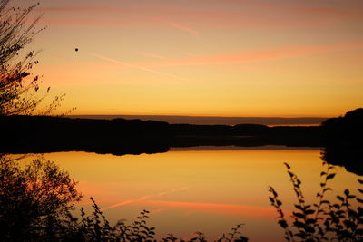 Scenic view of lake against orange sky