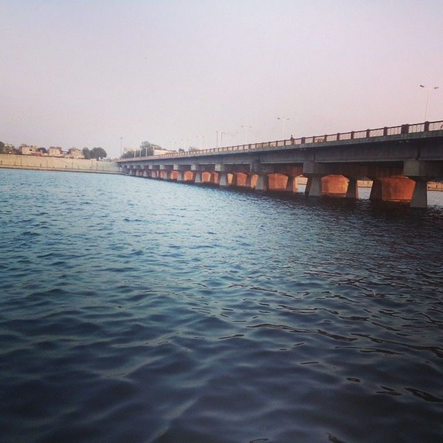 water, architecture, built structure, waterfront, clear sky, bridge - man made structure, connection, river, building exterior, copy space, rippled, sea, bridge, reflection, sky, outdoors, nature, no people, tranquility, pier