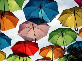 Low angle view of umbrellas hanging against sky