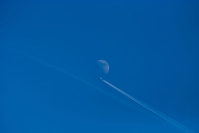 Low angle view of vapor trail against blue sky