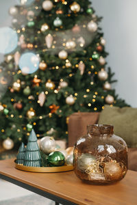 Christmas decor on side table over traditional christmas tree background. 