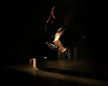 Close-up of coffee cup on table against black background