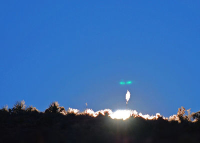 Scenic view of bright sun against clear blue sky