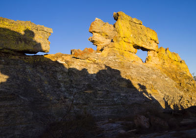 Low angle view of rock formation against sky