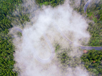 Aerial view of countryside road passing through the forest and mountain