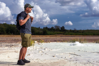 Hiker visits the caldera, a small circular crater with a marsh of sulphurous waters from the volcano