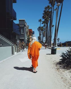 Rear view of man walking on snow