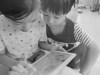 High angle view of siblings sitting on floor