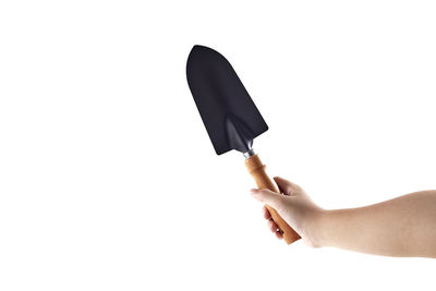 Close-up of hand holding umbrella against white background
