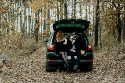 A couple in love celebrates halloween in costumes and makeup with a bouquet of dried flowers