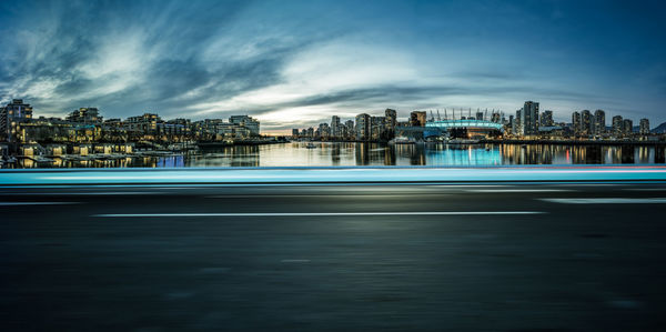 Sea by buildings against sky in city