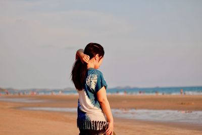 Rear view of woman standing on beach