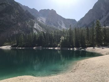 Scenic view of lake by mountains against sky