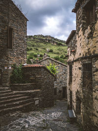 Old building by town against sky