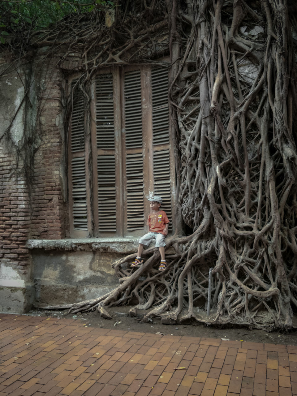 MAN SITTING ON BUILDING