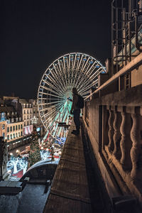 Illuminated ferris wheel in city at night