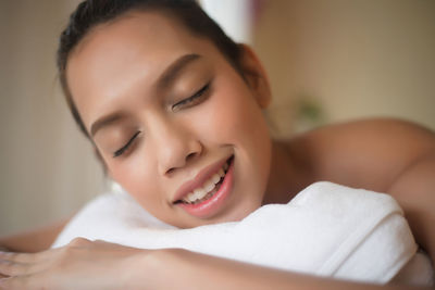 Close-up of smiling young woman lying on massage table in spa