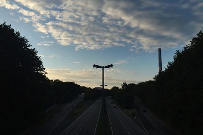 Empty road against cloudy sky