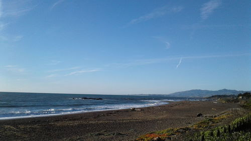 Scenic view of beach against blue sky