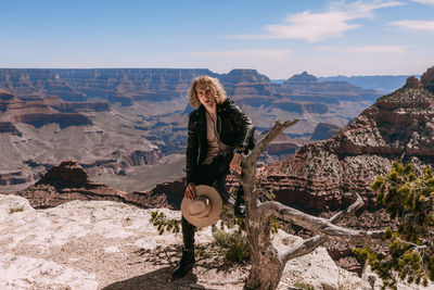 Woman on rock against sky